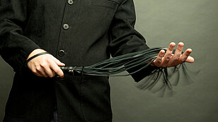 Männlich dominant hält eine Lederpeitsche für BDSM-Sex mit Spanking